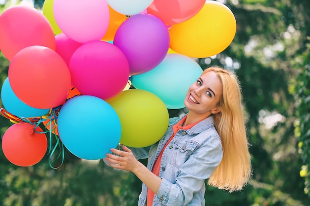 Junge schöne Frau mit Luftballons im Freien