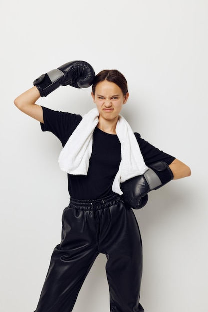 Foto junge schöne frau mit schwarzen boxhandschuhen posiert beim sport-fitness-training