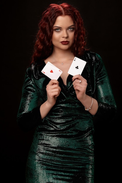 Junge schöne Frau mit Spielkarten über Schwarzem. Kasino