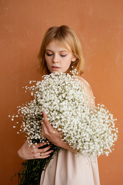 Junge schöne Frau mit Strauß der zarten Frühlingsblumen