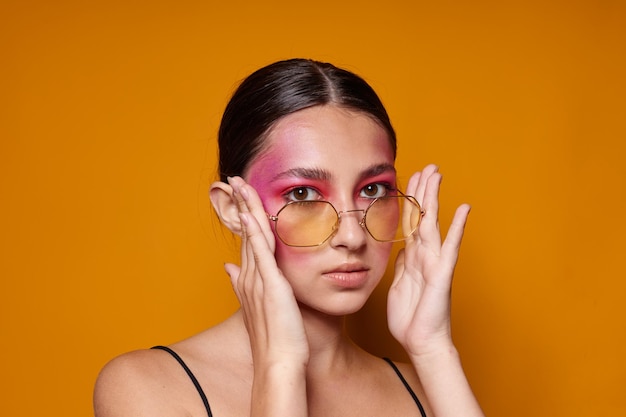 Junge schöne Frau Mode Brille rosa Gesicht Make-up posiert attraktiven Look isoliert Hintergrund unverändert