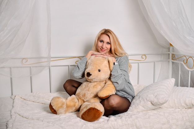 junge schöne Frau posiert mit Teddybär
