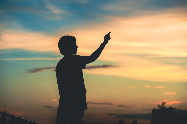 Junge schöne Frau schaut bei Sonnenuntergang hoffnungsvoll auf ihre Hände. Konzepterfolg in der Hand