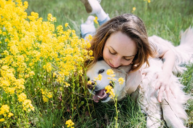 Junge schöne Frau und ihr Golden Retriever-Hund haben Spaß im Sommer