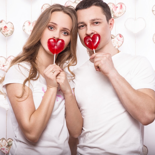 Junge, schöne Frau und Mann in der Liebe am Valentinstag mit Süßigkeit