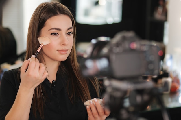 Junge schöne Frau und professionelle Schönheit bilden Künstler Vlogger Aufnahme Make-up-Tutorial im Studio