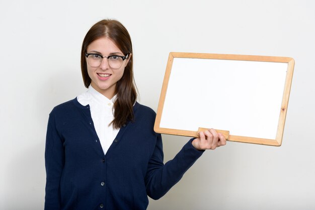 junge schöne Geschäftsfrau gegen weiße Wand