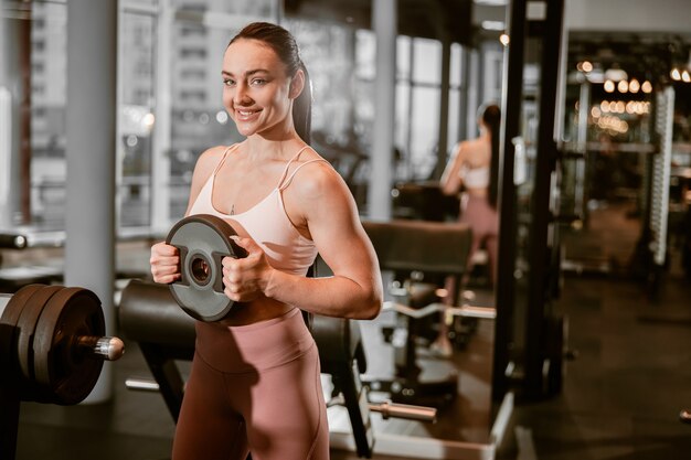 Junge schöne, kaukasische, starke Frau macht Übungen im Fitnessstudio