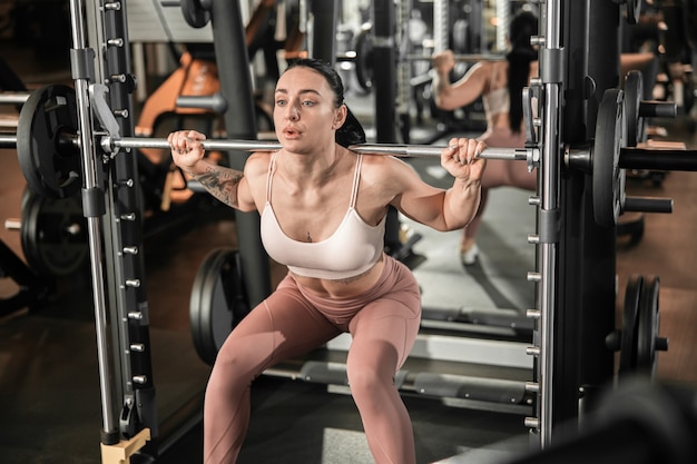 Junge schöne, kaukasische, starke Frau macht Übungen im Fitnessstudio