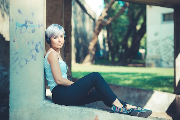 junge schöne kurze blaue Haare Hipster Frau mit Kopfhörer Musik