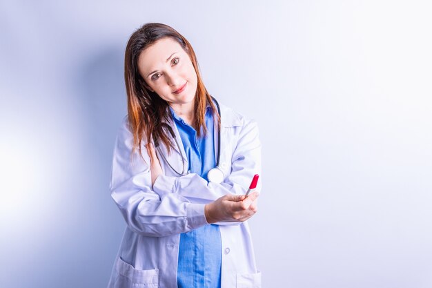 Junge schöne medizinische Frau, die vor einem positiven Schwangerschaftstest zeigt. Konzeptnachrichten der Schwangerschaft vom Arzt. Gynäkologie