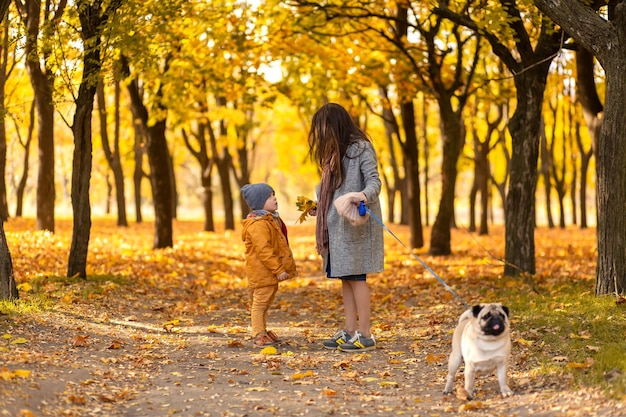 Junge schöne Mutter verbringt Zeit auf einem Spaziergang mit ihrem geliebten kleinen Sohn im Herbstpark Glückliche Familie genießt Herbsttage