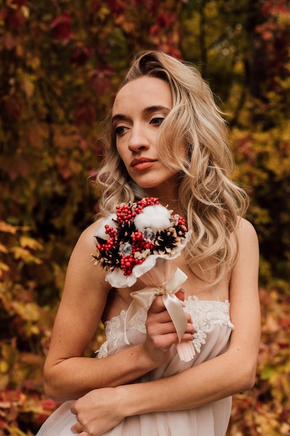 Junge schöne sexy Mädchen blonde Braut posiert mit einem Blumenstrauß