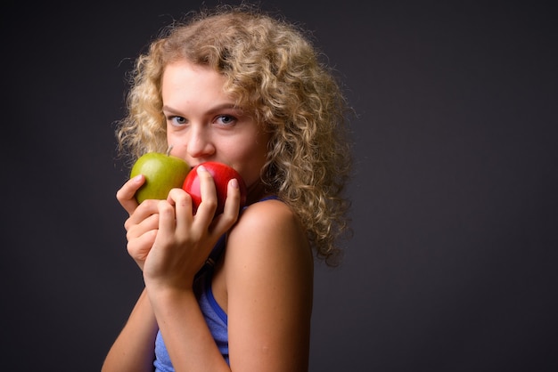 Junge schöne Sportfrau bereit für Turnhalle, die gesunden Apfel hält