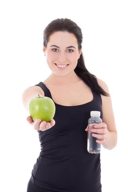 Junge schöne sportliche Frau mit Flasche Wasser und Apfel isoliert auf weißem Hintergrund