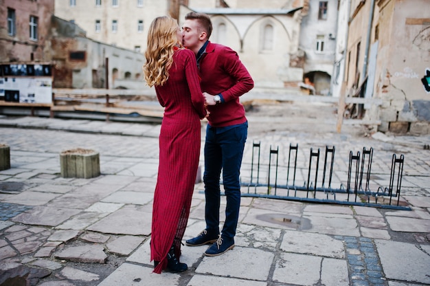 Junge schöne stilvolle Modepaare in einem roten Kleid in der Liebesgeschichte an der alten Stadt