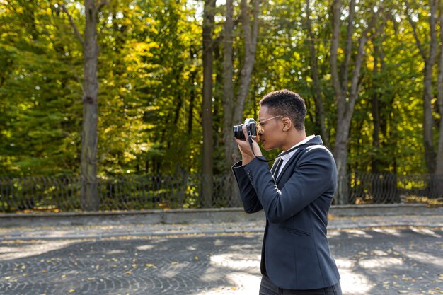 Junge schöne touristische Fotografin macht Foto im Park auf analoger Filmkamera