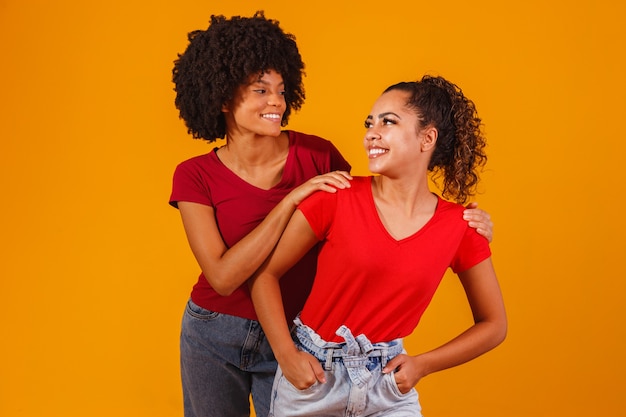 Junge schöne und glückliche Afro-Freundinnen, die in die Kamera lächeln.