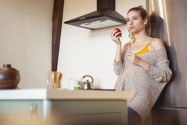 Junge Schönheit. Erstaunliches Mädchen, das Apfel in der Hand hält, während sie ein süßes Dessert kreiert