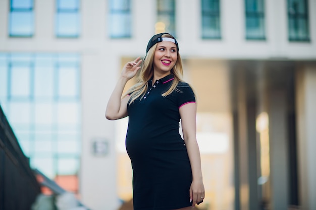 Junge schwangere Frau auf Hintergrundwohngebäude
