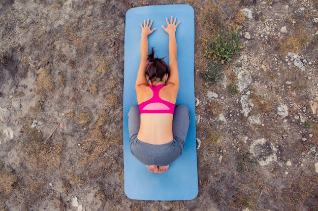 Junge schwangere Frau macht Yoga im Freien