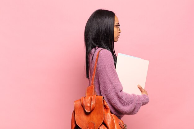 Junge schwarze Frau auf der Profilansicht, die den Raum voraus kopieren, nachdenken, sich vorstellen oder träumen möchte. studentisches Konzept