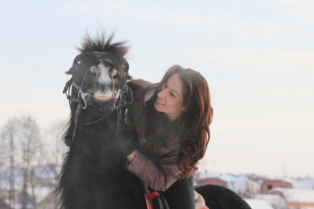 Junge schwarzhaarige Frau mit einem Pferd, Nahaufnahme