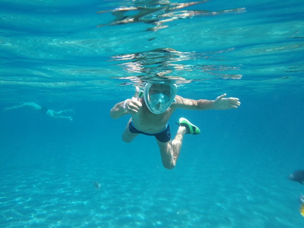 Junge schwimmen unter wasser in masken auf dem meer