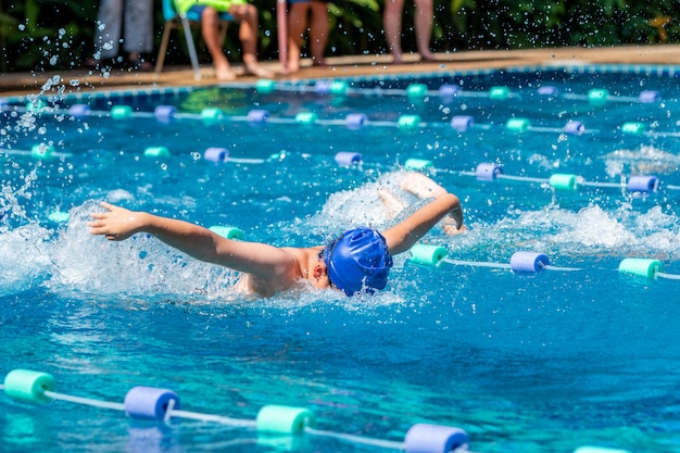 Junge schwimmer, der schmetterlingsschlag an einem pool tut