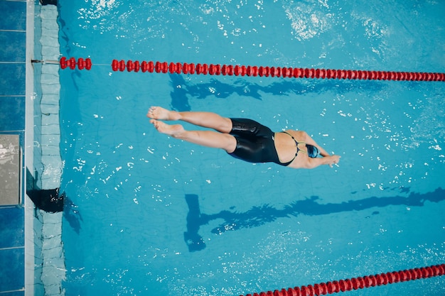 Junge Schwimmerin springt ins Schwimmbad