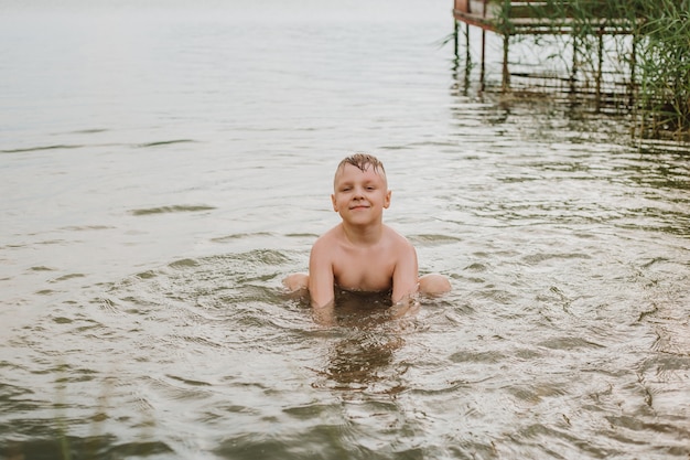 Foto junge schwimmt im see. sommerferien.