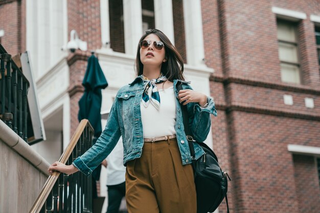 junge selbstbewusste Dame, die auf dem Rodeo Drive einkauft, geht die Treppe hinunter