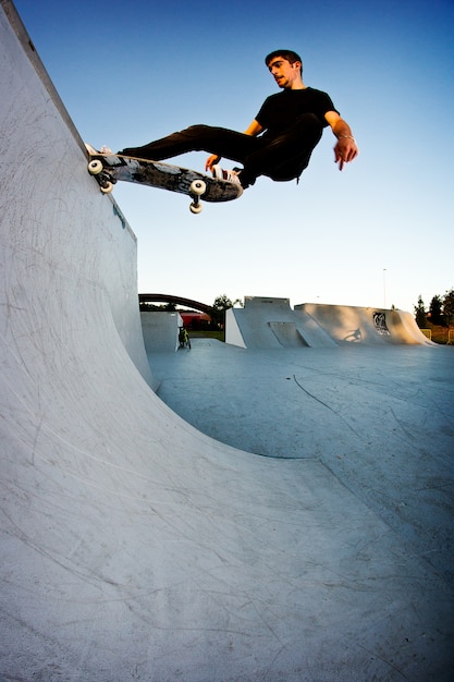 Junge Skateboarding in einem Skatepark am Nachmittag