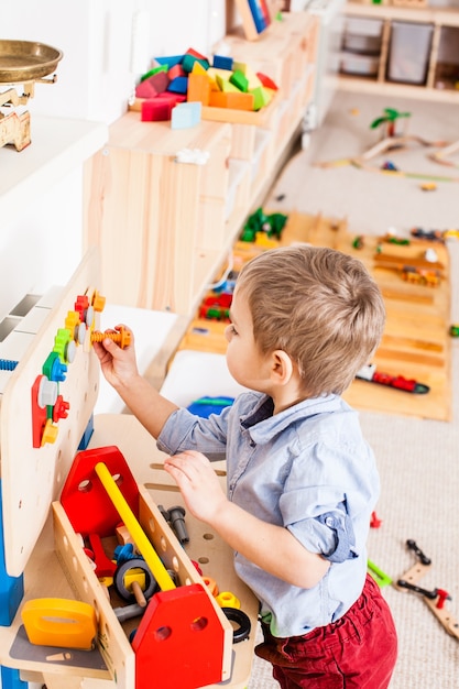 Junge spielt mit Bauholzinstrumenten im Kindergarten