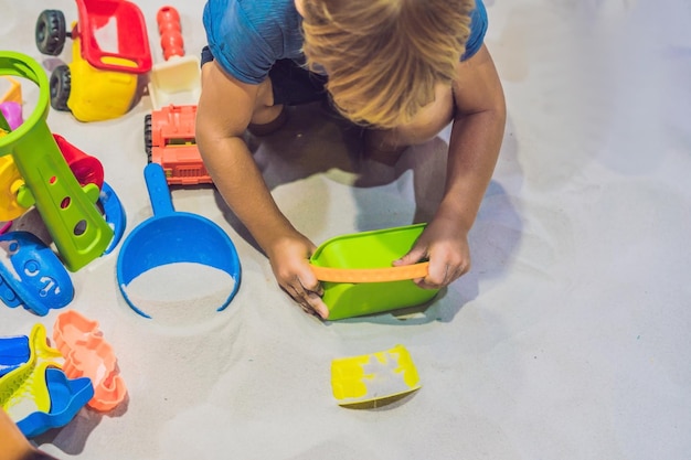 Junge spielt mit Sand in der Vorschule. Die Entwicklung des Feinmotorkonzepts. Kreativität Spielkonzept.