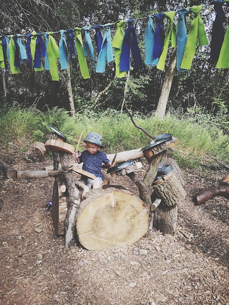 Foto junge spielt musik mit holz und küchenutensilien an land