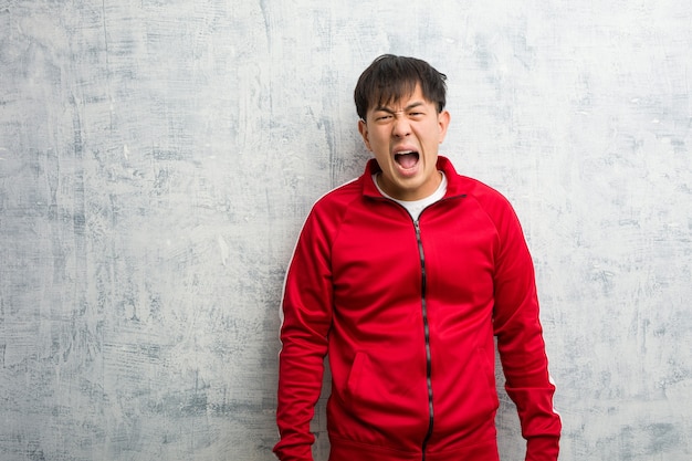 Junge Sport Fitness Chinesen schreien sehr wütend und aggressiv