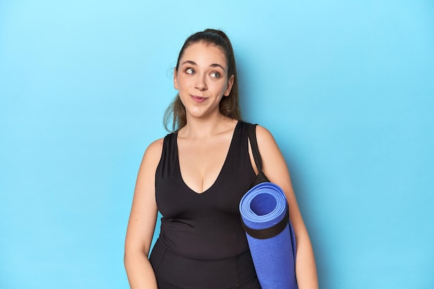 Junge Sport-Fitness-Frau auf blauem Hintergrund