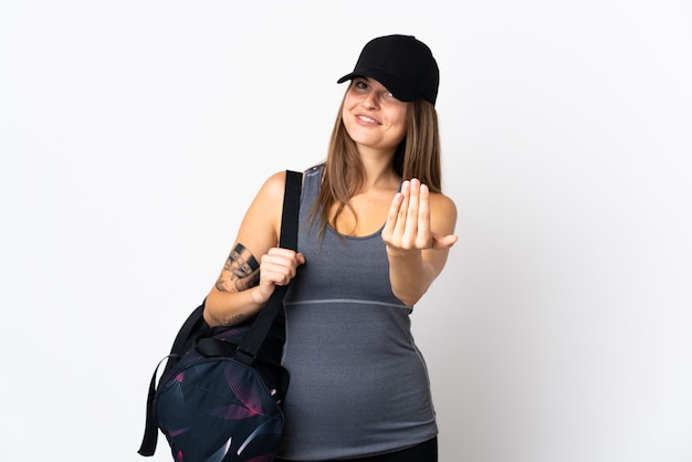 Junge Sport slowakische Frau mit Sporttasche über isolierte Einladung, mit Hand zu kommen. Schön, dass du gekommen bist