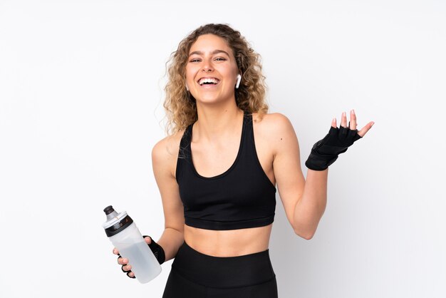 Foto junge sportfrau auf weißer wand mit sportwasserflasche