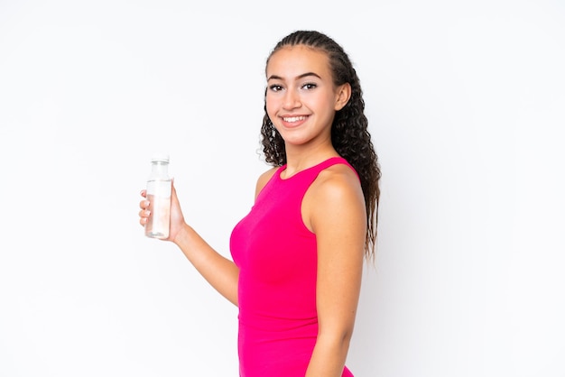 Junge Sportfrau mit einer Flasche Wasser lokalisiert auf Weiß, die viel lächelt