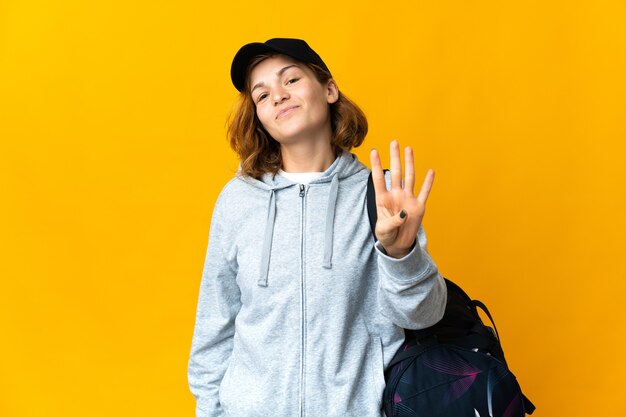 Junge Sportgeorgianerin mit Sporttasche über lokalisiertem Hintergrund glücklich und vier mit den Fingern zählend