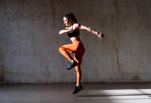 Junge Sportlerin trainiert in einem Fitnessstudio mit Sportgeräten