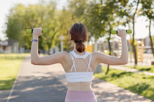 Foto junge sportliche frau, die draußen im park sport treibt