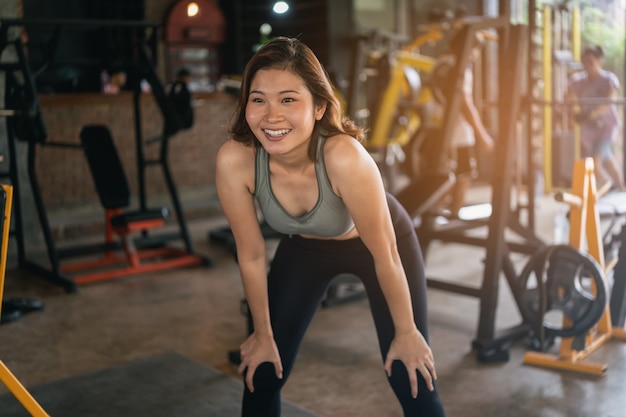 Junge sportliche Frau, die im Fitnessstudio, Fitness-Sportkonzept streckt