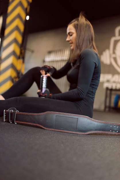 Junge sportliche Frau in Sportkleidung müde und macht eine Pause im Fitnessstudio.