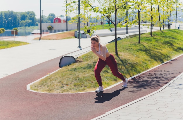 Junge sportliche Frau macht Dehnübungen auf der Promenade