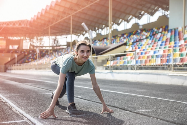 Junge sportliche Frau macht Morgengymnastik im Freien auf dem Stadion