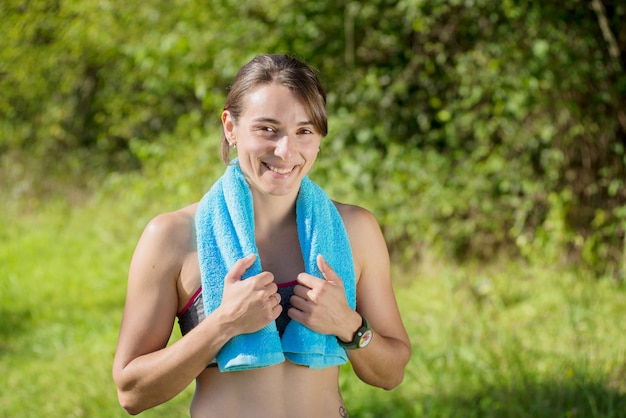 Junge sportliche Frau mit blauem Tuch in der Landschaft