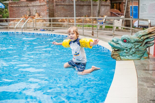 Junge springen in das Wasser des Schwimmbades